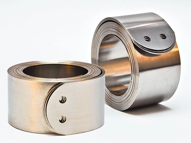 Constant Force Springs Two constant force springs displayed side by side—one lying flat and the other standing upright—showcasing their coiled design and versatility. Different orientations, same reliable force—constant force springs deliver smooth, consistent motion in a variety of applications.